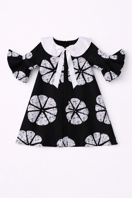 Black dress with white floral patterns on a white background