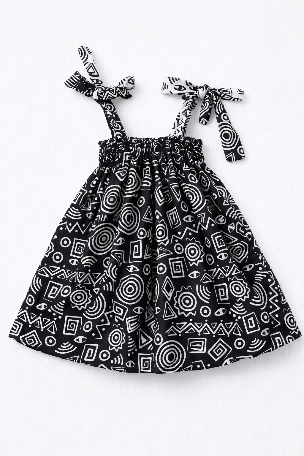 Black and white patterned dress with tie straps on a white background