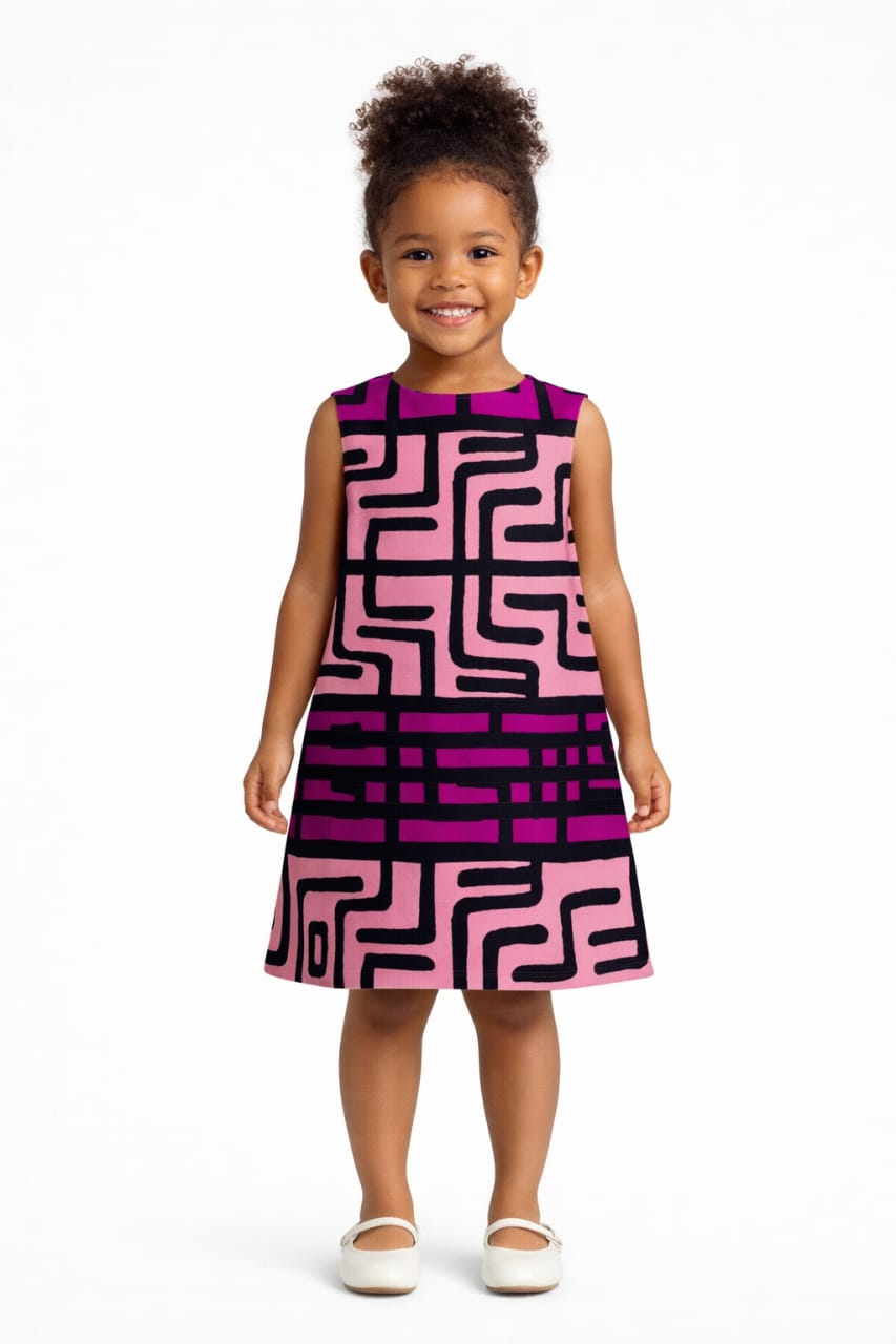 Young girl wearing a pink and purple patterned dress on a white background