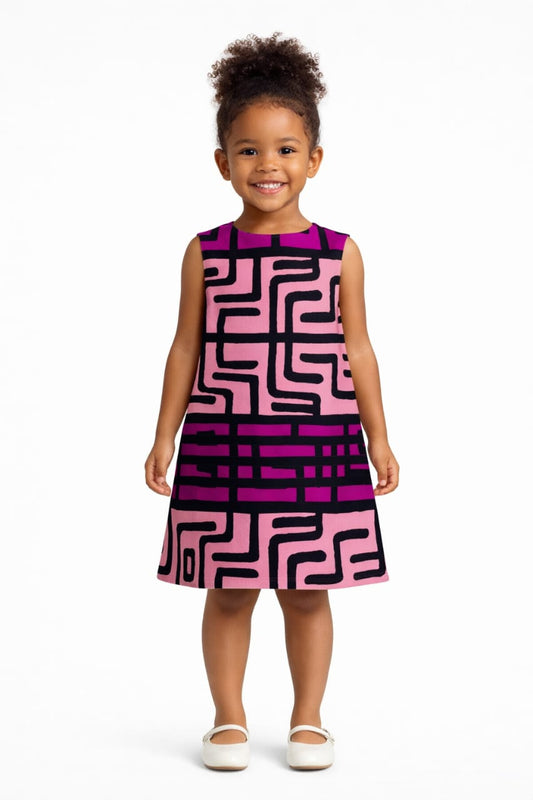 Young girl wearing a pink and purple patterned dress on a white background