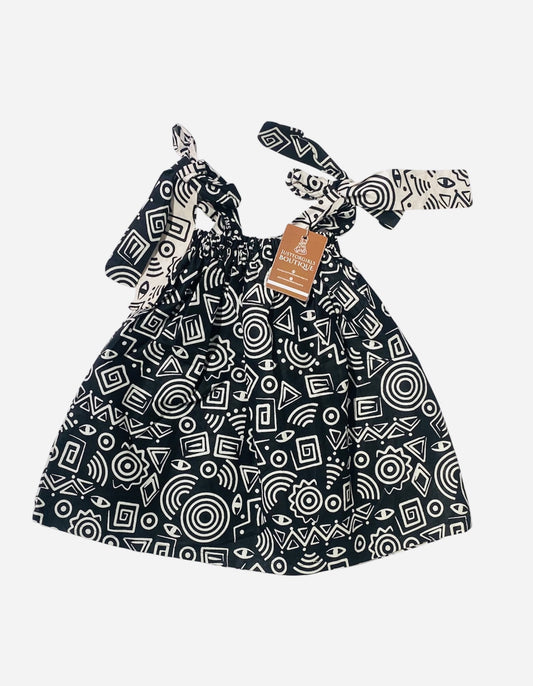 Black and white patterned dress with tiestraps on a white background