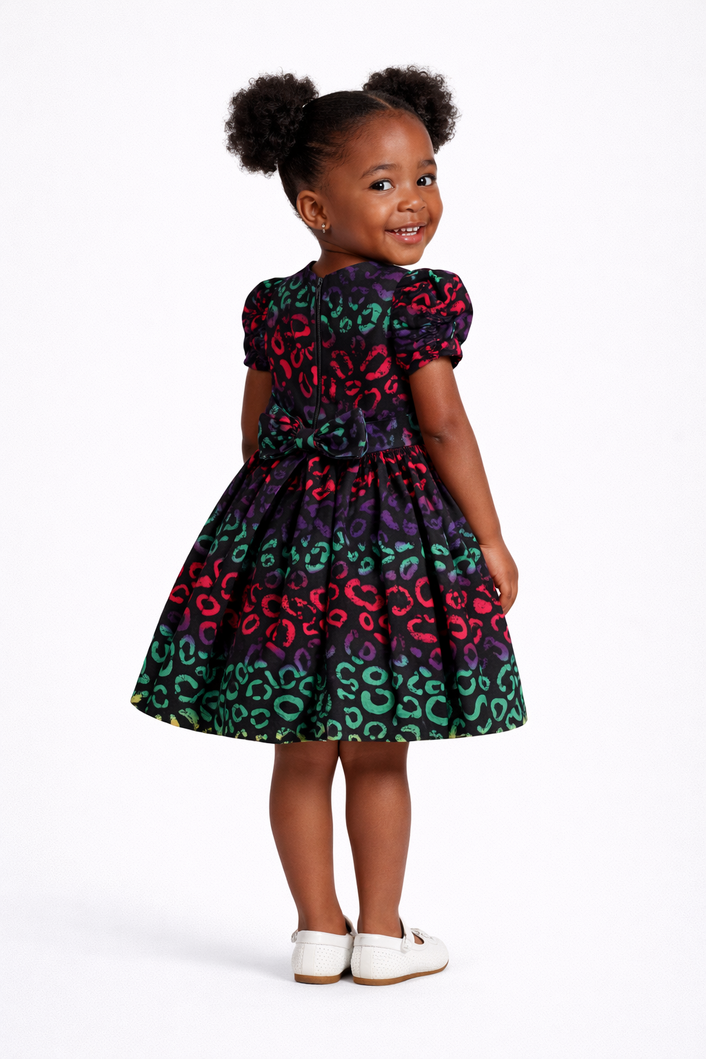 Young girl wearing a colorful dress with a pattern on a white background